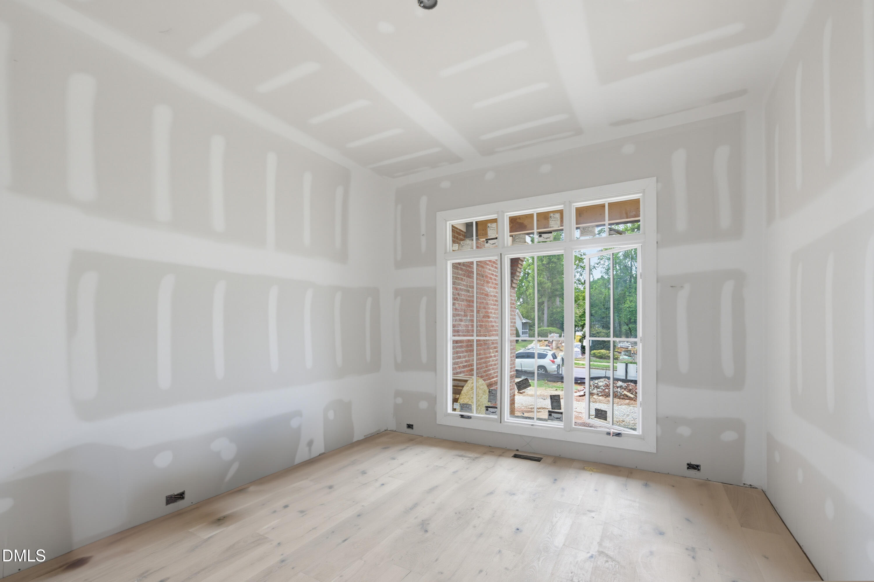 7508 Grist Mill Road Raleigh, NC 27615 - Photo 10 of 32 a view of an empty room with wooden floor and a window
