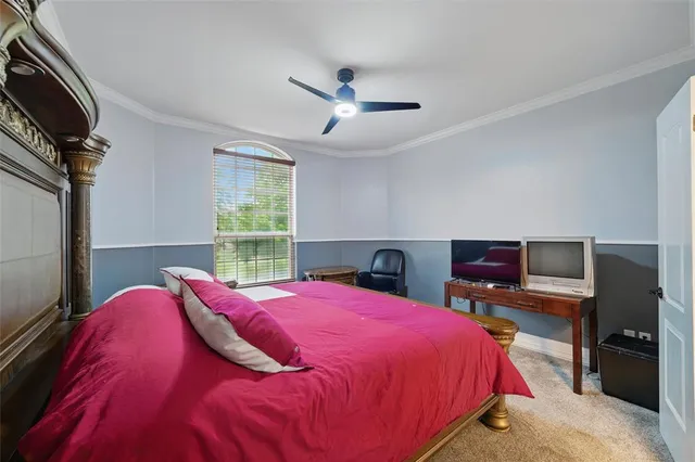 a bedroom with a bed and a flat tv screen on the dresser