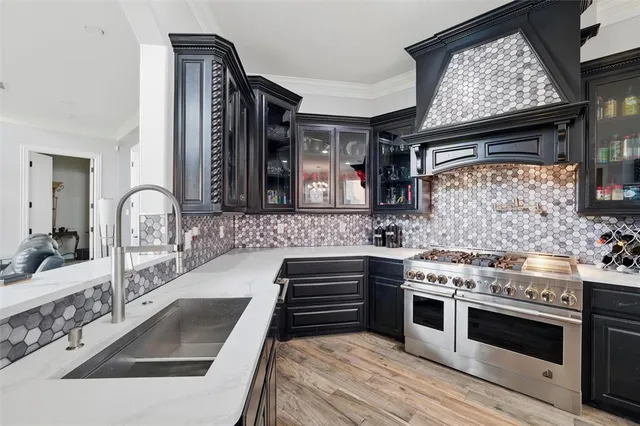 a kitchen with granite countertop stainless steel appliances a stove sink and cabinets