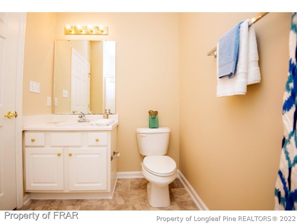 3050 McDuffies Mill Road, Unit 7 Fayetteville, NC 28311 - Photo 16 of 22 a bathroom with a toilet a sink and a mirror