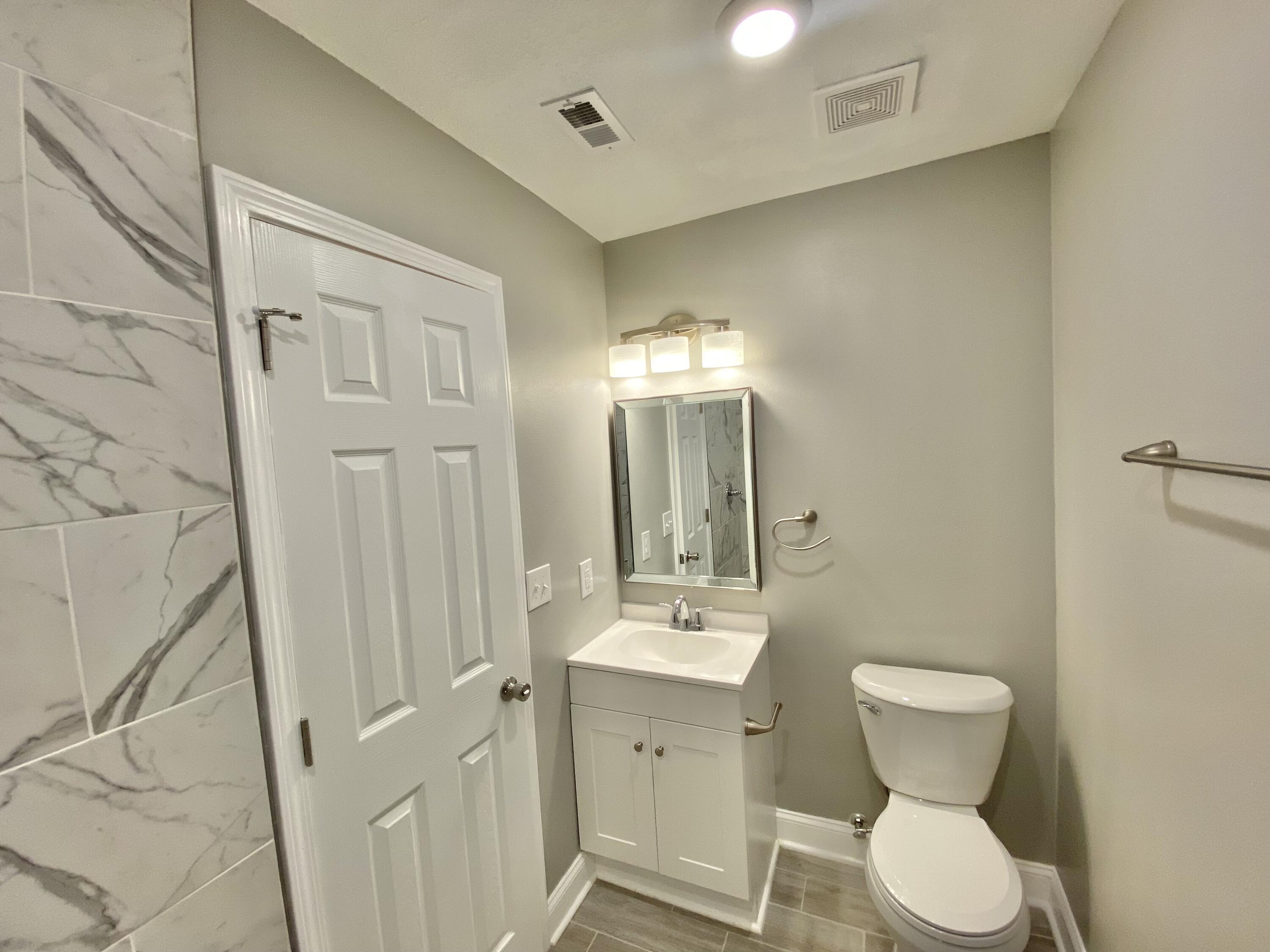 795 Bay Street Crestview, FL 32536 - Photo 22 of 34 a bathroom with a toilet sink and mirror