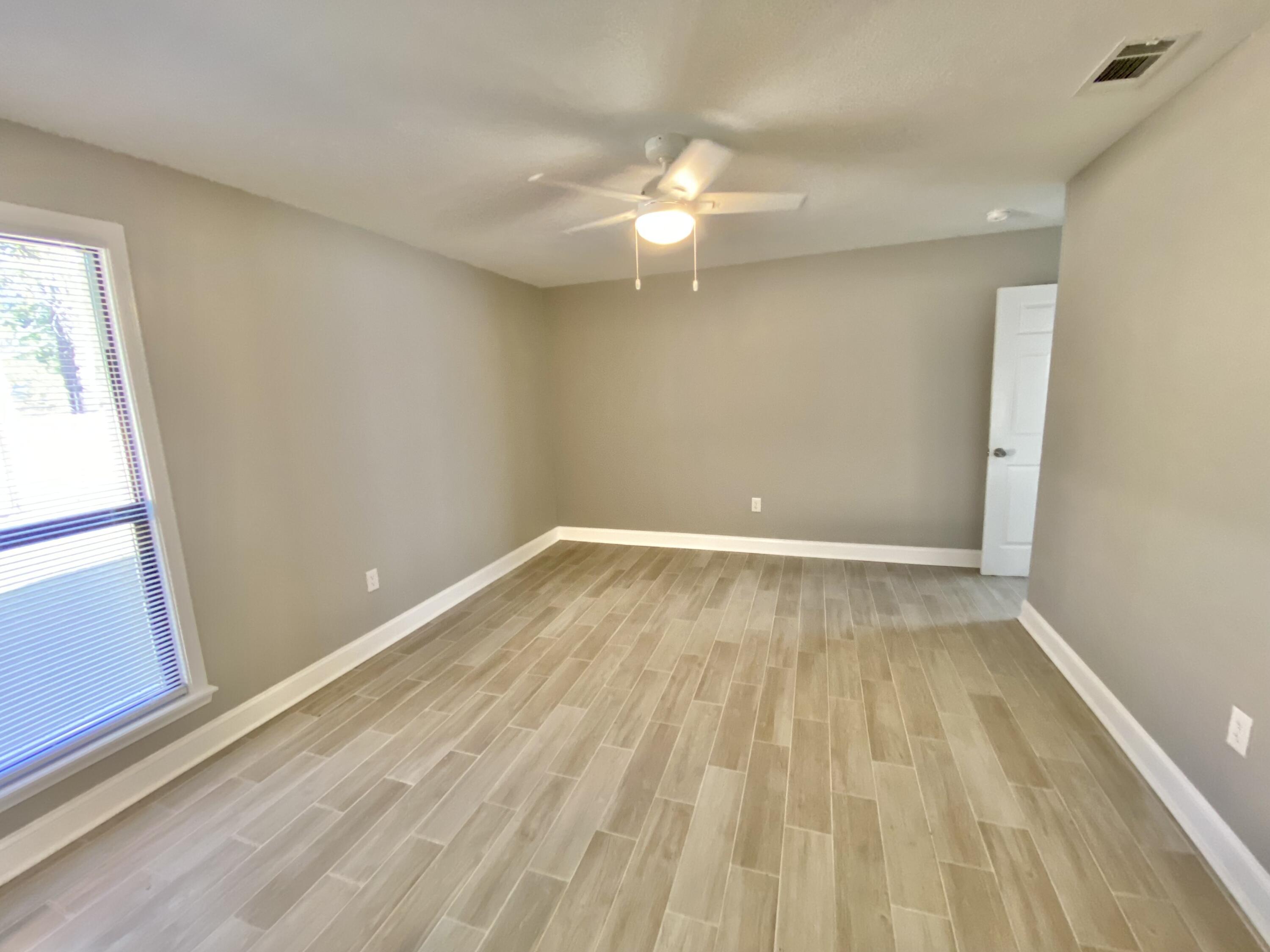 795 Bay Street Crestview, FL 32536 - Photo 23 of 34 wooden floor in an empty room with a window