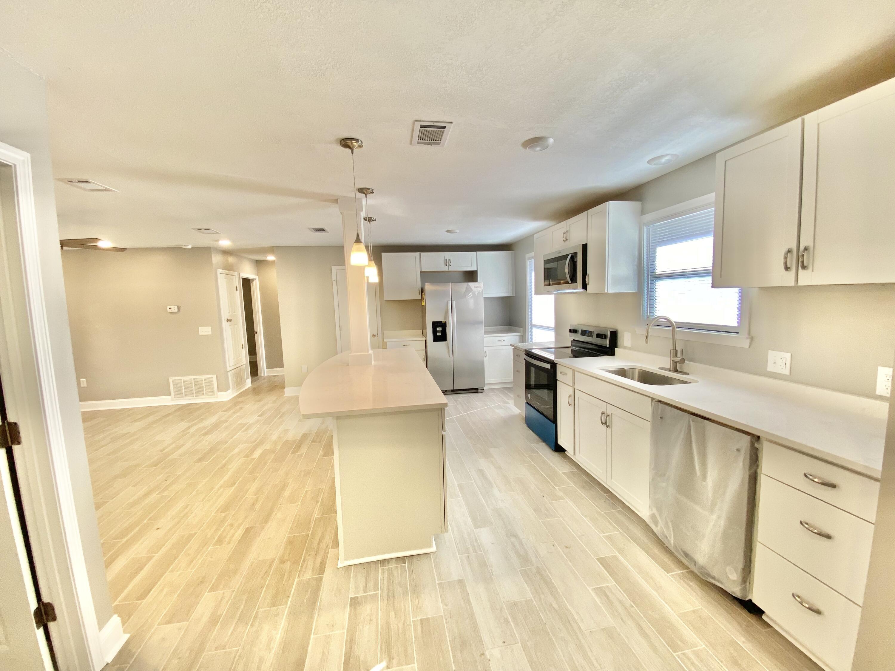 795 Bay Street Crestview, FL 32536 - Photo 8 of 34 a large kitchen with cabinets a sink and a stove top oven