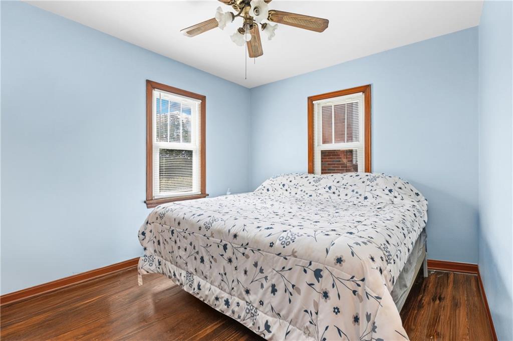 118 Oak Spring Road Canonsburg, PA 15317 - Photo 14 of 32 Bright bedroom with hardwood floors and soft blue walls, creating a welcoming retreat. Multiple windows allow plenty of natural light throughout the day.