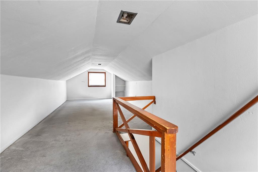 118 Oak Spring Road Canonsburg, PA 15317 - Photo 17 of 32 Spacious finished attic with neutral tones and a large window, perfect for a home office, playroom, or bonus living space. Built-in shelving adds convenience and functionality.