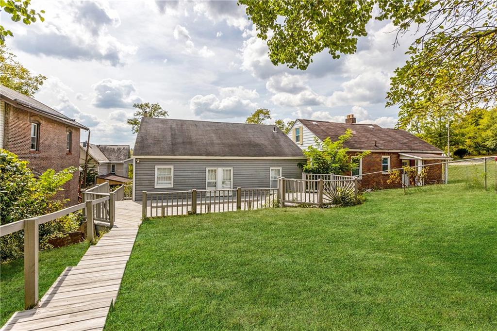 118 Oak Spring Road Canonsburg, PA 15317 - Photo 18 of 32 The back of the home features a large deck with walkways leading into the spacious yard. Vinyl siding and multiple windows create a clean, low-maintenance exterior with plenty of natural light inside.