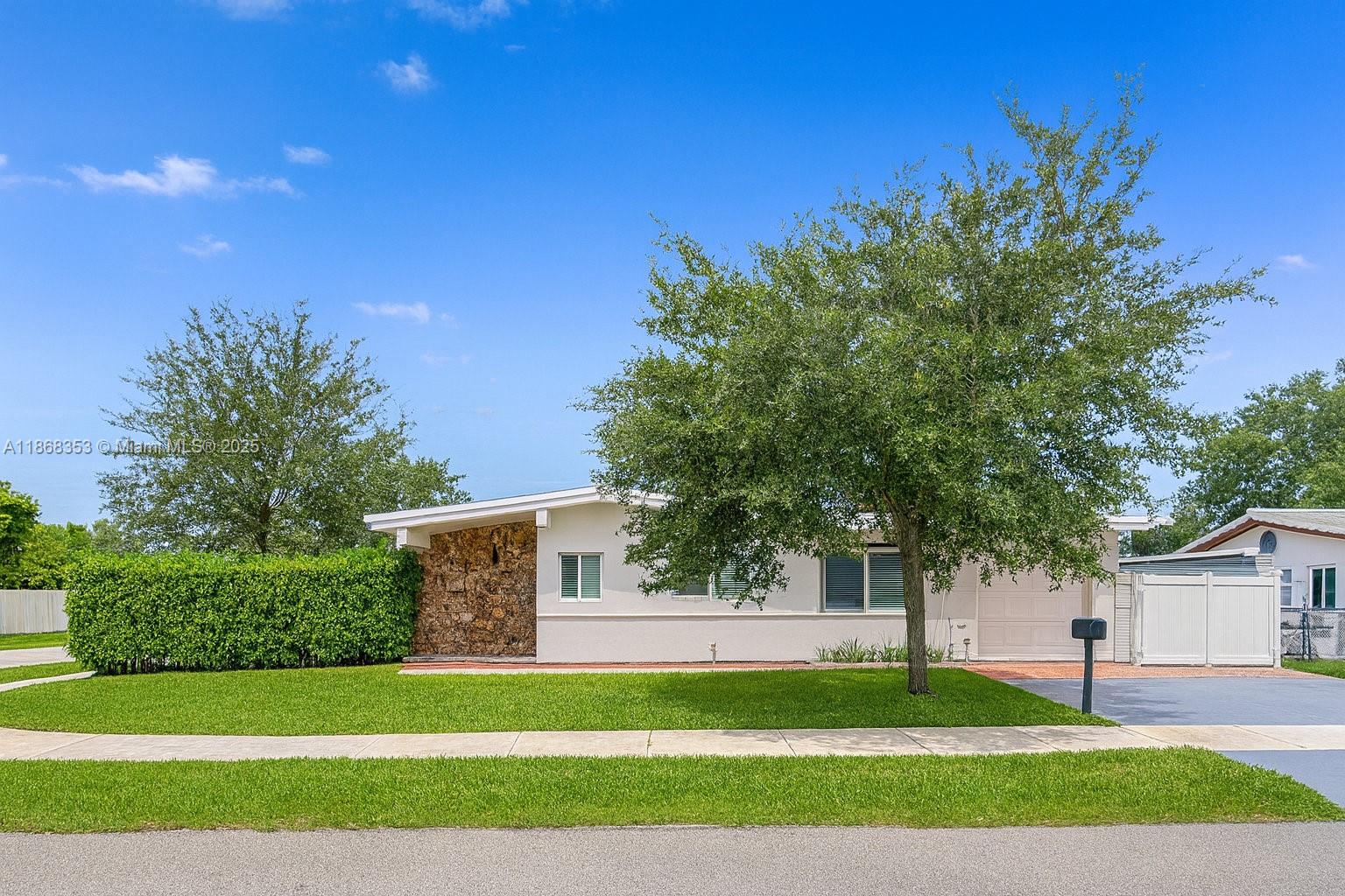 a view of a house with a yard and tree s