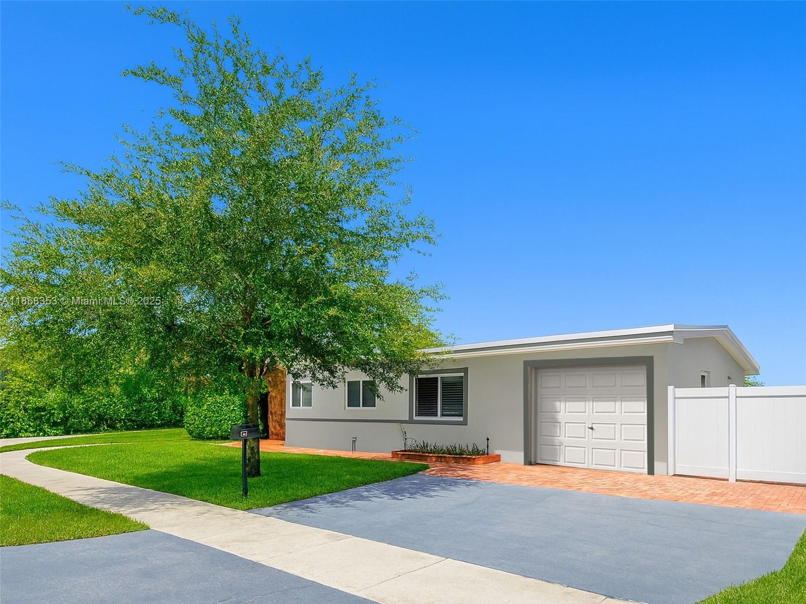 5250 Southwest 96th Avenue Miami, FL 33165 - Photo 2 of 16 a front view of a house with a yard and garage