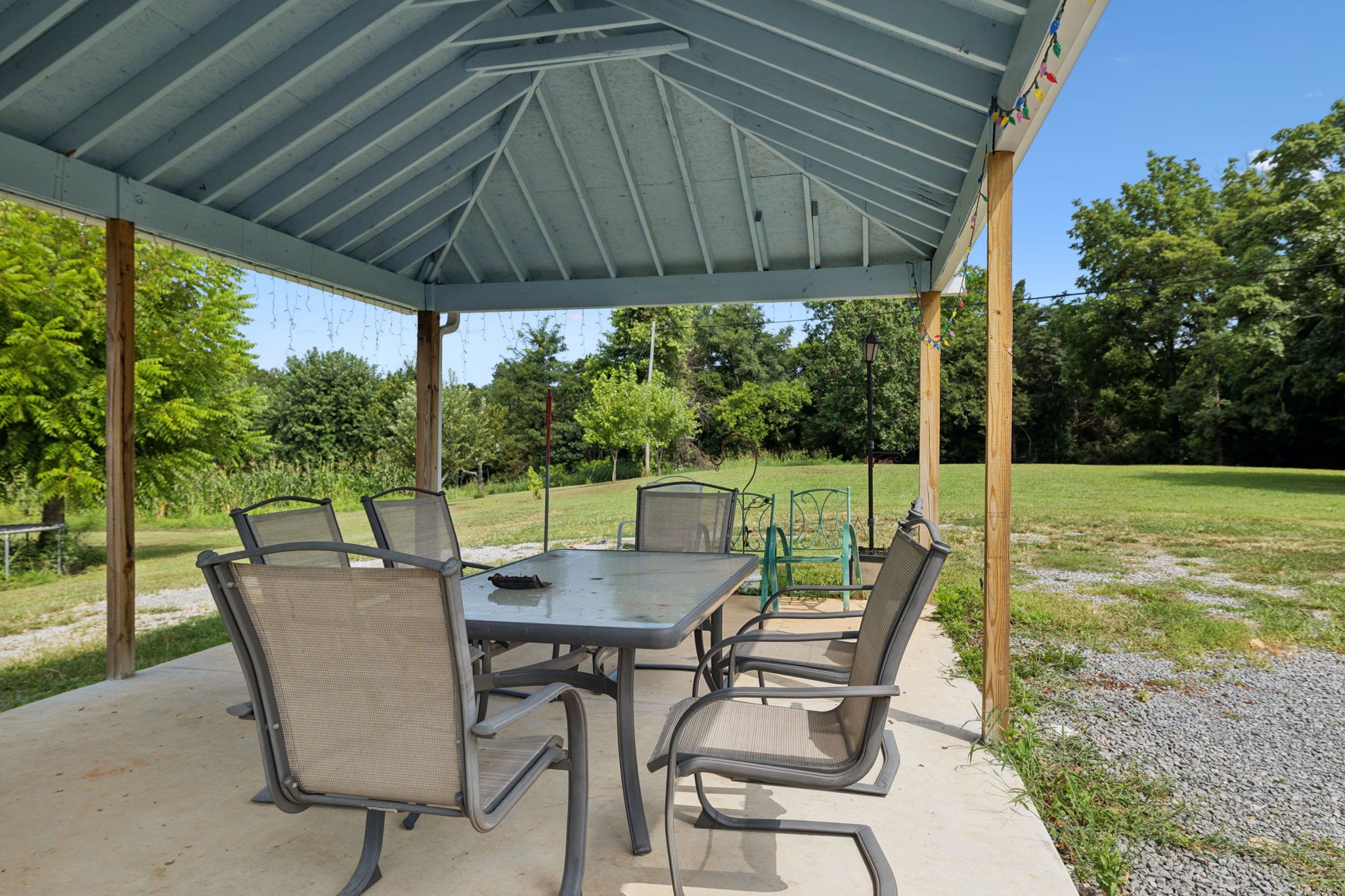 942 Fay Creek Road Wartrace, TN 37183 - Photo 3 of 68 a view of a patio with table and chairs under an umbrella with a small yard