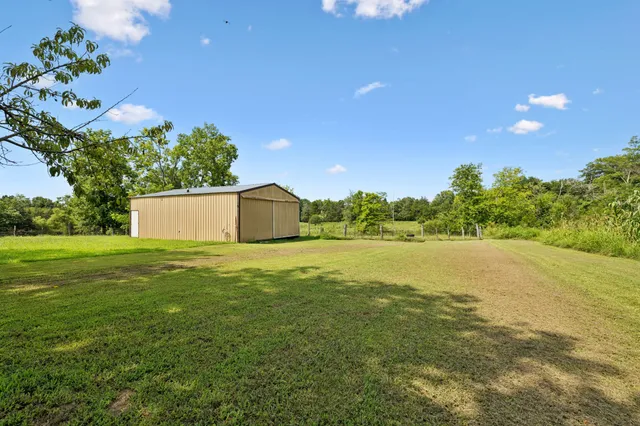 a view of a house with a patio and a yard