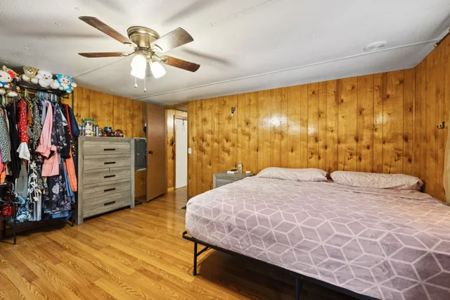 a kitchen with a refrigerator a stove top oven a sink dishwasher and wooden cabinets with wooden floor