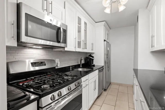 a kitchen with stainless steel appliances a stove a microwave and cabinets