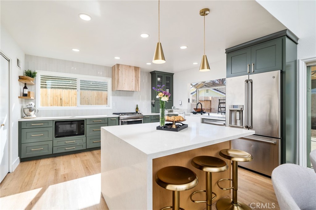 6870 Saddleback Place Rancho Cucamonga, CA 91701 - Photo 8 of 33 a kitchen with refrigerator a stove and chairs