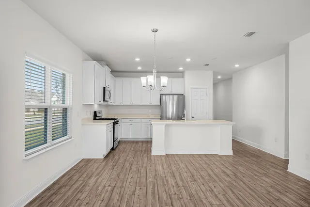a view of kitchen with wooden floor and electronic appliances