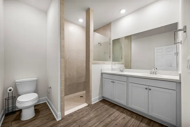 a bathroom with a double vanity sink toilet and shower