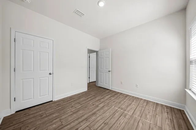 a view of an empty room with wooden floor