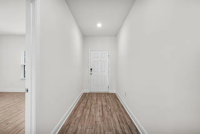 a view of a hallway with wooden floor