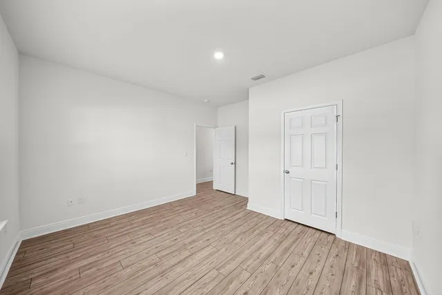 a view of an empty room with wooden floor