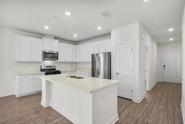 a kitchen with stainless steel appliances a refrigerator stove microwave and cabinets