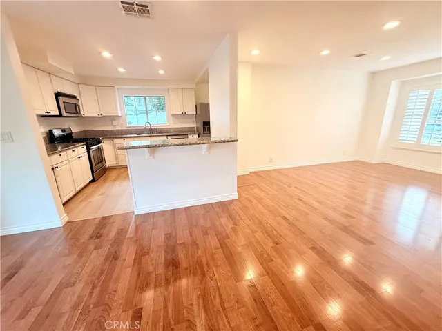 a view of kitchen with granite countertop cabinets and wooden floor