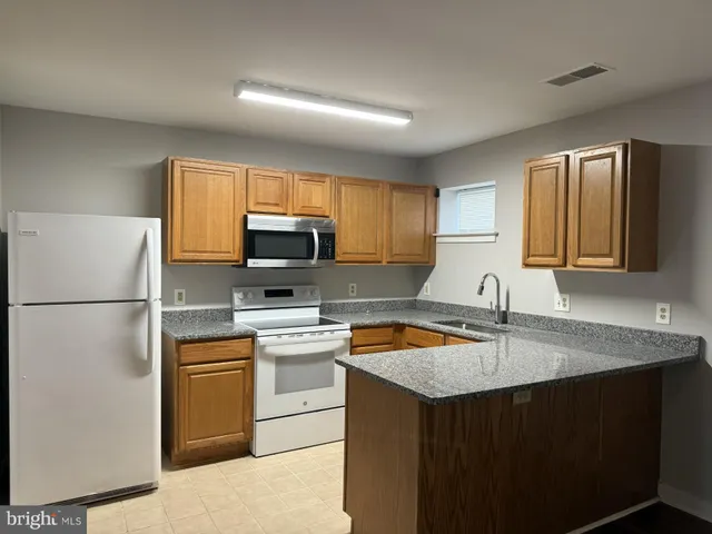 a kitchen with a sink a stove a refrigerator a center island and a window