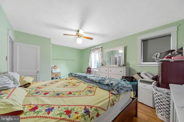 a bed sitting in a bedroom next to a window with wooden floor
