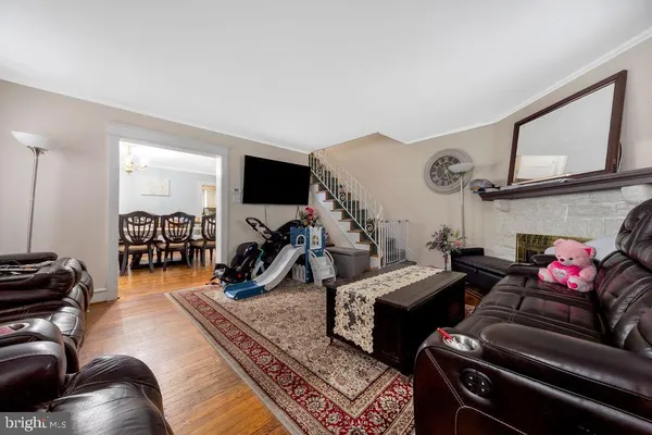 a living room with furniture a wooden floor and a flat screen tv