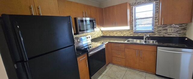9273 Southwest 8th Street, Unit 209 Boca Raton, FL 33428 - Photo 2 of 8 a kitchen with granite countertop cabinets and refrigerator