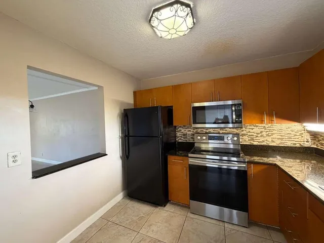 a kitchen with a refrigerator and a stove top oven