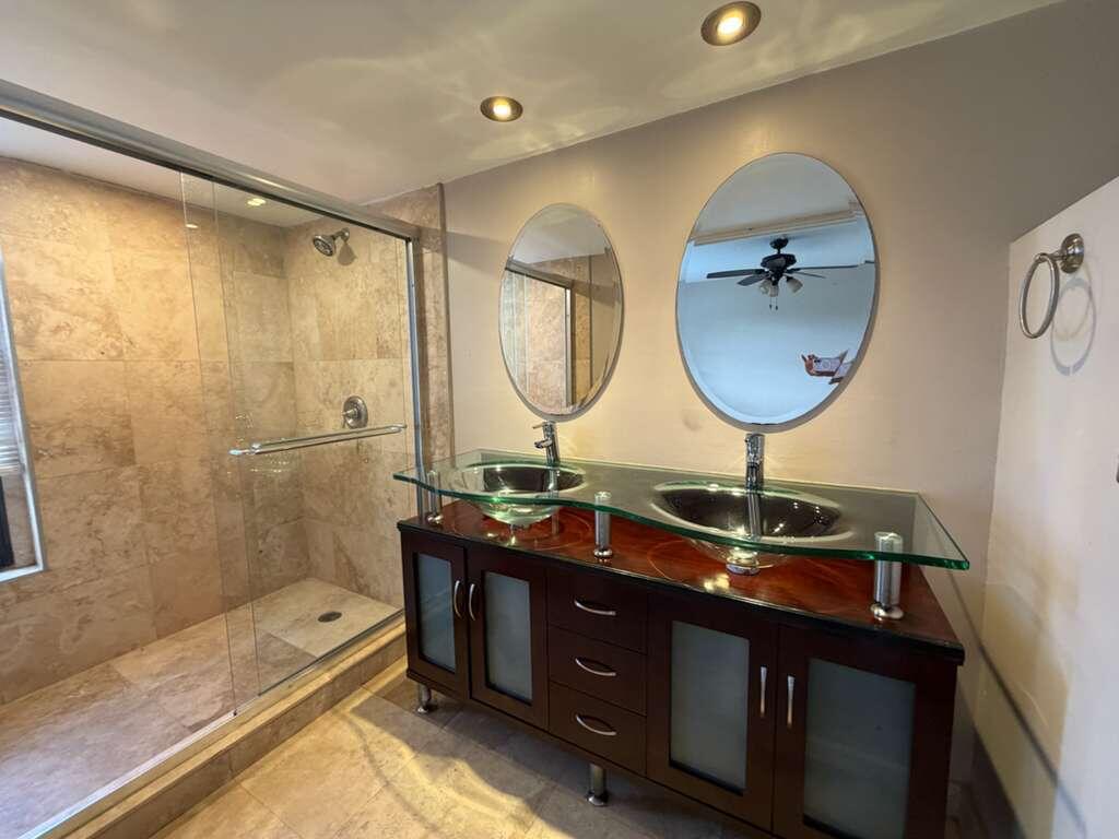 9273 Southwest 8th Street, Unit 209 Boca Raton, FL 33428 - Photo 4 of 9 a bathroom with a double vanity sink and mirror