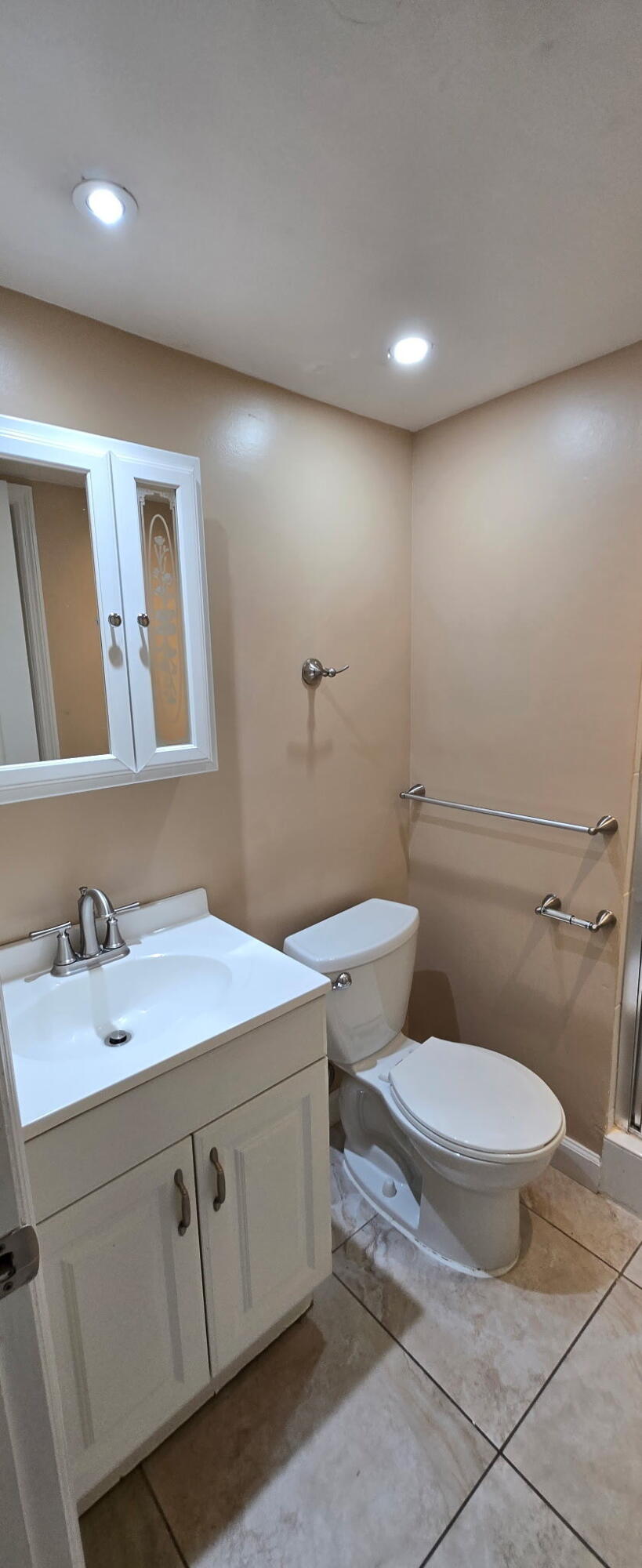 9273 Southwest 8th Street, Unit 209 Boca Raton, FL 33428 - Photo 6 of 8 a bathroom with a toilet sink and mirror