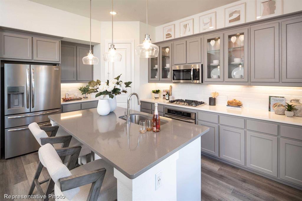 a kitchen with a sink a kitchen island and stainless steel appliances