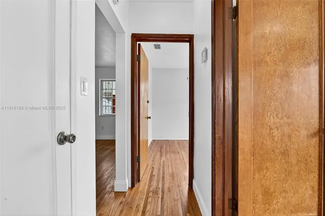 a view of a hallway with wooden floor