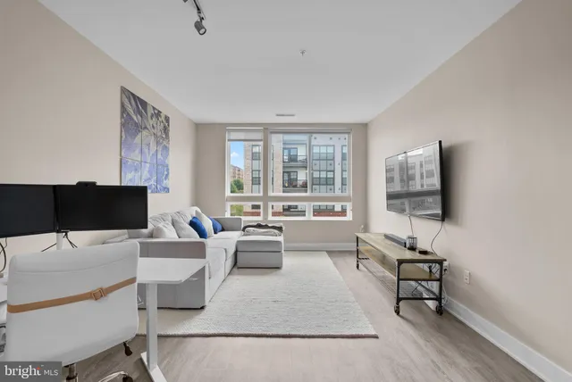 a living room with furniture wooden floor and a large window