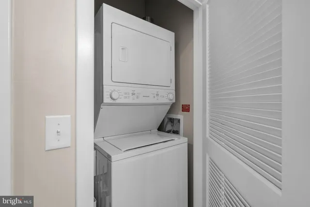a view of a hallway with wooden floor and a bathroom