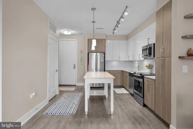 a kitchen with stainless steel appliances granite countertop a stove a refrigerator and a sink