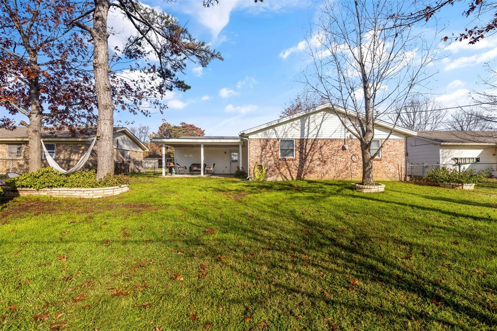 708 East Prairie View Road Crowley, TX 76036 - Photo 19 of 21 Expansive lawn featuring mature trees with a raised stone planter
