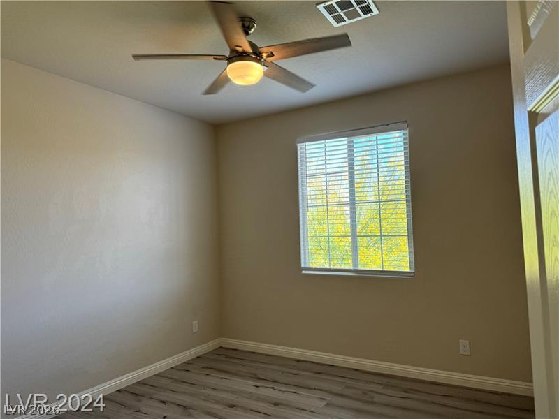 9056 Tony Ridge Avenue Las Vegas, NV 89148 - Photo 21 of 32 A well-lit room showcasing a contemporary ceiling fan and durable flooring.