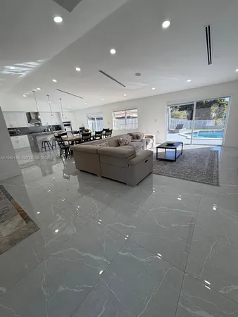 a living room with furniture and a view of kitchen