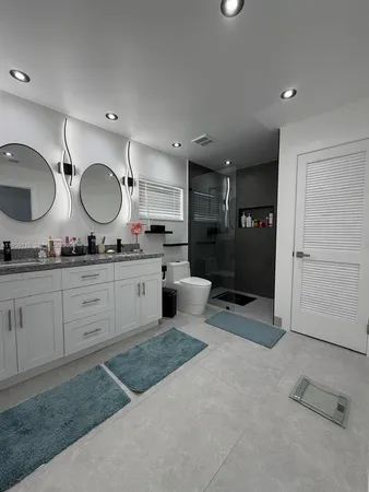 a spacious bathroom with a granite countertop sink mirror and cabinets