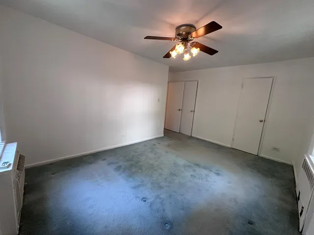 a view of an empty room with a chandelier fan