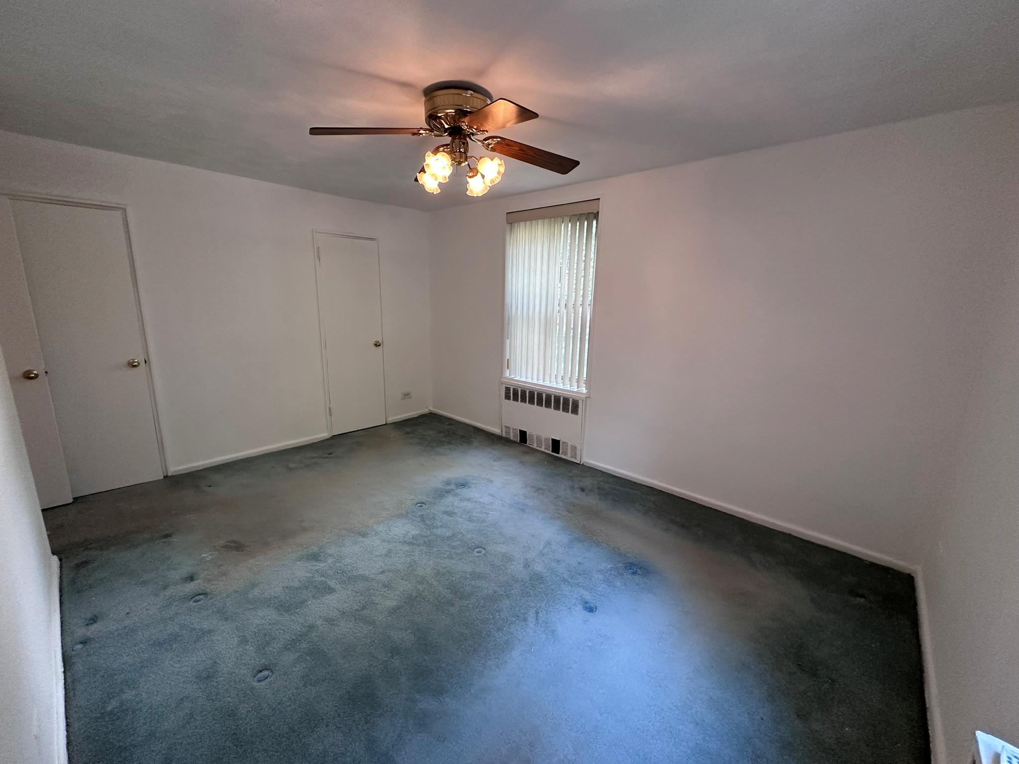 209-25 18th Avenue, Unit 1C Queens, NY 11360 - Photo 12 of 26 a view of an empty room with a chandelier fan