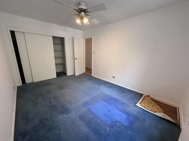 an empty room with a ceiling fan and a window
