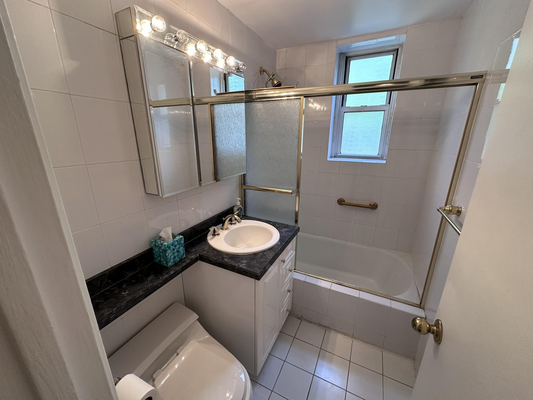 209-25 18th Avenue, Unit 1C Queens, NY 11360 - Photo 15 of 26 a bathroom with a sink and mirror