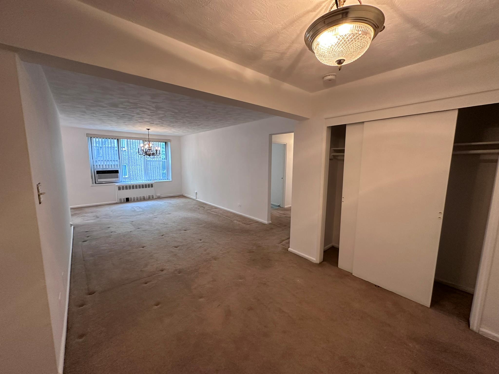 209-25 18th Avenue, Unit 1C Queens, NY 11360 - Photo 16 of 26 a view of an empty room with window and wooden floor