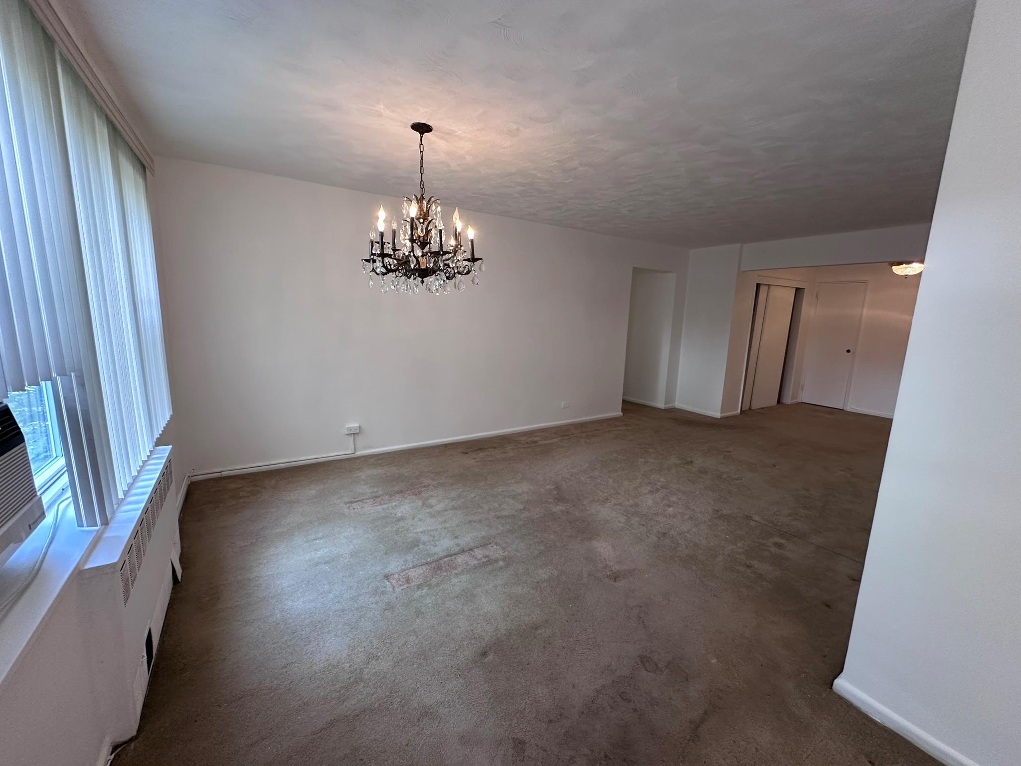 209-25 18th Avenue, Unit 1C Queens, NY 11360 - Photo 18 of 26 a view of an empty room with a chandelier