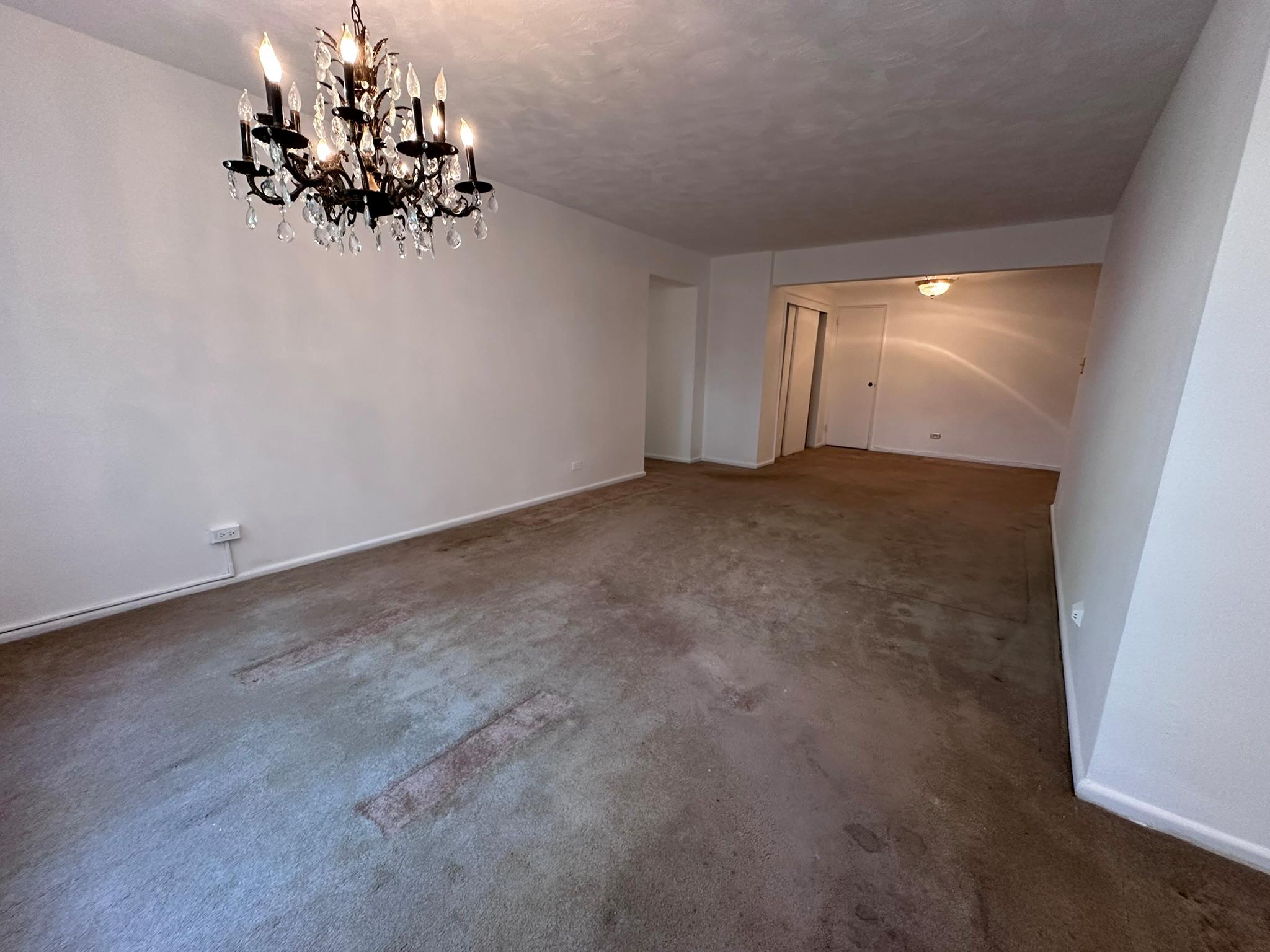 209-25 18th Avenue, Unit 1C Queens, NY 11360 - Photo 20 of 26 an empty room with a chandelier