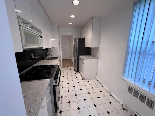 a kitchen with granite countertop a refrigerator and a sink
