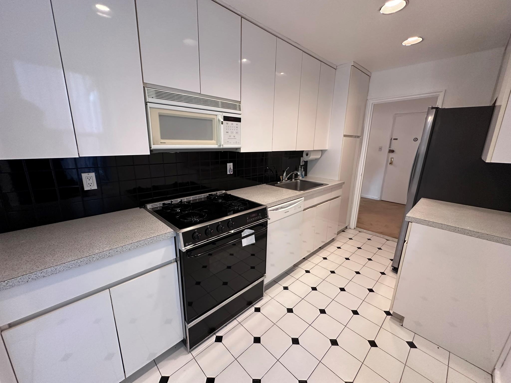 209-25 18th Avenue, Unit 1C Queens, NY 11360 - Photo 7 of 26 a kitchen with granite countertop a sink a stove and refrigerator