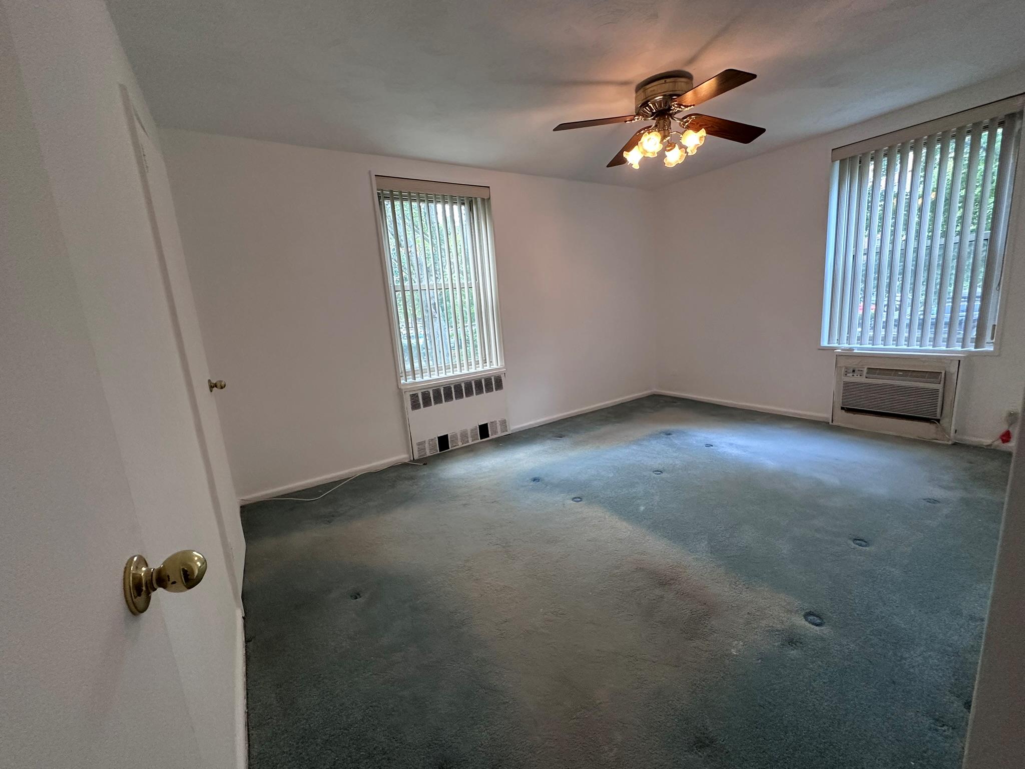 209-25 18th Avenue, Unit 1C Queens, NY 11360 - Photo 10 of 26 an empty room with windows and fan
